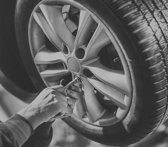 Technician tightening a wheel on a car in the workshop